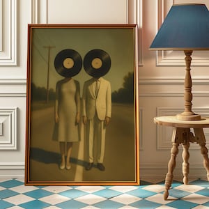Pode incluir: Obra de arte emoldurada com duas figuras com cabeças de discos de vinil numa estrada. Uma figura usa um vestido, a outra um fato. A obra de arte está numa moldura dourada, com uma paleta de cores suaves.