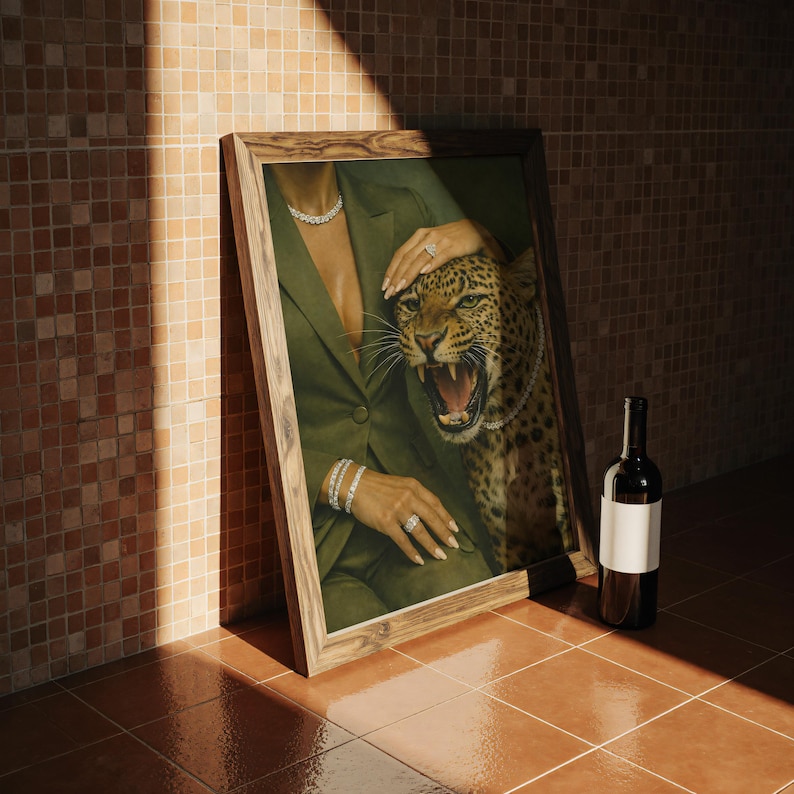 May include: A framed artwork featuring a woman in a green blazer with diamond jewelry, alongside a snarling leopard. A bottle of wine with a blank label leans against the frame. The setting is a tiled floor and wall.