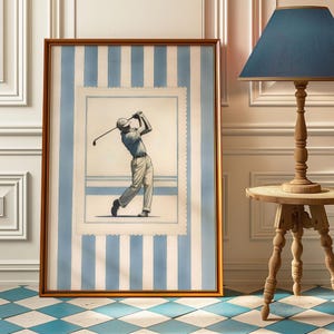 May include: Artwork in a gold frame depicting a golfer mid-swing, set against a light blue and white striped backdrop. The framed picture is on a blue and white checkered floor. A wooden lamp with a blue lampshade is to the right.