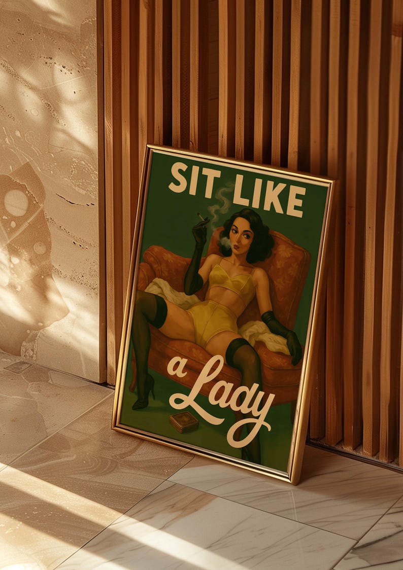 May include: Framed vintage-style print with a green background and the text "SIT LIKE a Lady." The artwork depicts a woman in yellow lingerie, black gloves, and stockings, smoking a cigarette while seated in a red armchair.