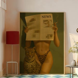 May include: A framed artwork featuring a woman in leopard print bikini bottoms holding a newspaper with the headline "NEWS". A leopard is beside her. The woman is smoking a cigarette. The background is a muted green.