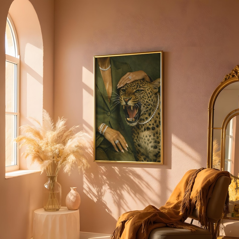 May include: A framed artwork featuring a leopard with a pearl necklace, roaring with its mouth open. The artwork is set against a green background, with a person's arm and hand adorned with jewelry. The frame is gold.