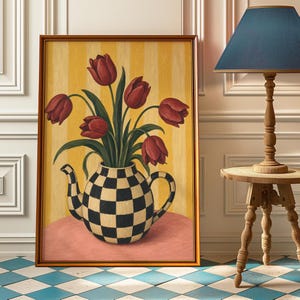 Puede incluir: Obra de arte enmarcada que presenta un jarrón con forma de tetera a cuadros blancos y negros lleno de tulipanes rojos. El fondo tiene rayas verticales amarillas. La obra está enmarcada en un marco dorado.