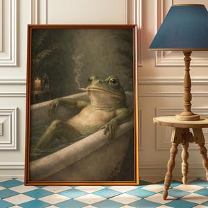 May include: A framed print depicting a frog in a bathtub, smoking a cigarette. The frog is green with a pale belly. The artwork is in a gold frame, with a vintage style. The background is dark green, with a small table and lamp visible.