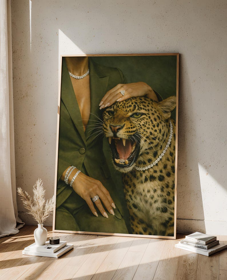 May include: A framed print featuring a woman in a green blazer with diamond jewelry, petting a roaring leopard wearing a diamond necklace. The artwork has a vintage aesthetic with a neutral background.