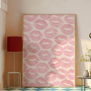 May include: A framed artwork featuring a pattern of pink lipstick kiss prints on a cream background. The artwork is displayed in a room with a red lamp and a blue and white checkered floor. The overall theme is decorative art.