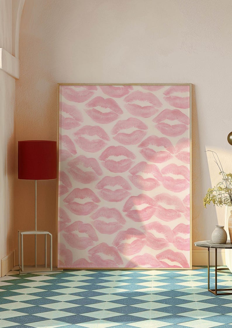 May include: A framed artwork featuring a pattern of pink lipstick kiss prints on a cream background. The artwork is displayed in a room with a red lamp and a blue and white checkered floor. The overall theme is decorative art.