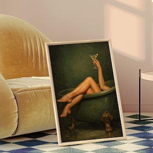 May include: Framed art print featuring a person relaxing in a green bathtub, holding a cocktail. The artwork has a vintage aesthetic, with a gold-colored frame. The image is set against a dark green background.