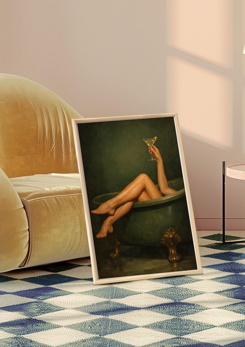 May include: Framed art print featuring a person relaxing in a green bathtub, holding a cocktail. The artwork has a vintage aesthetic, with a gold-colored frame. The image is set against a dark green background.