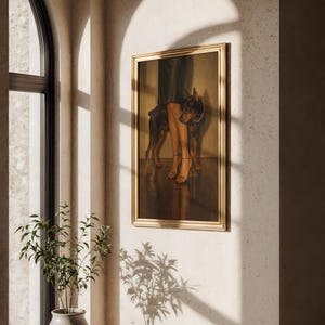 May include: A framed artwork featuring a Doberman Pinscher standing next to a person's legs and feet. The painting has a gold frame and is displayed on a textured wall. The scene is illuminated by natural light.