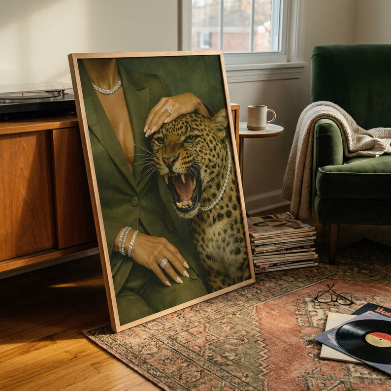 May include: Framed artwork featuring a woman in a green suit with a leopard. The leopard is wearing a pearl necklace. The woman is wearing diamond jewelry. The artwork is leaning against a wall on a patterned rug.