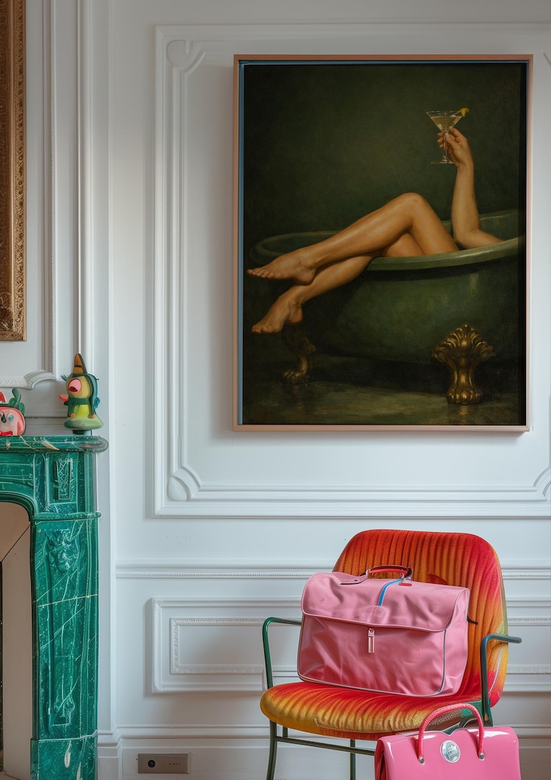 May include: A framed painting depicts a person relaxing in a green bathtub, holding a martini. A pink satchel bag sits on a red and orange chair. The room features white walls and a green fireplace.