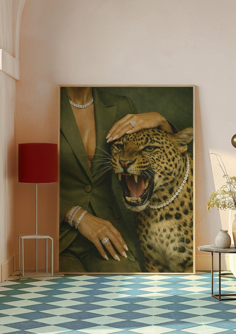 May include: A framed artwork featuring a leopard with an open mouth, wearing a diamond necklace. A person in a green blazer and diamond jewelry is touching the leopard. The artwork is displayed in a room with a red lamp and a blue and white checkered floor.