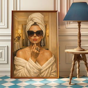 Op de afbeelding: Een ingelijst schilderij toont een vrouw in een witte handdoek en badjas, lippenstift aanbrengend. Ze draagt een zonnebril en sierlijke oorbellen. De achtergrond toont een badkamer met een spiegel en wandkandelaars. Het schilderij staat op een blauw-witte geblokte vloer.