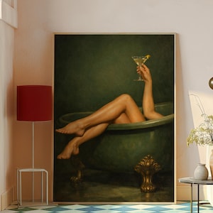 May include: A framed artwork depicts a person relaxing in a green clawfoot bathtub, holding a cocktail with a lemon twist. The artwork has a dark green background and a gold-colored ornate foot on the tub.