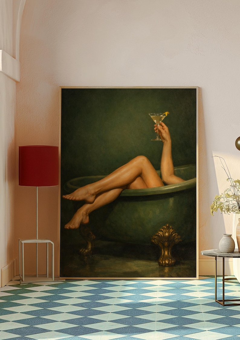 May include: A framed artwork depicts a person relaxing in a green clawfoot bathtub, holding a cocktail with a lemon twist. The artwork has a dark green background and a gold-colored ornate foot on the tub.