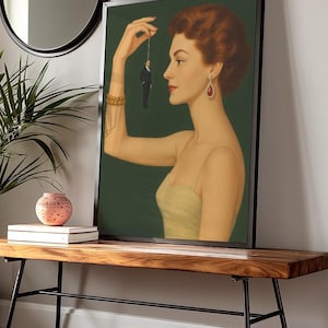 以下が含まれることがあります： ミニチュアの男性を持つ女性を描いた、額入りのアートプリント。 女性は赤毛、赤いイヤリング、黄色のドレスを着ています。 背景は濃い緑色です。 プリントは木製のベンチに飾られています。