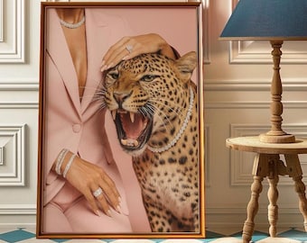 Könnte beinhalten: Gerahmtes Kunstwerk mit einem brüllenden Leoparden, der mit einer Diamantkette geschmückt ist. Eine Person in einem rosa Blazer und Schmuck ist im Bild. Das Kunstwerk ist vor einem rosa Hintergrund platziert.