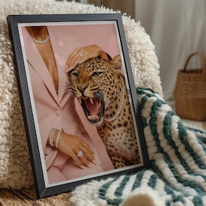 May include: Framed art print featuring a roaring leopard with a diamond necklace, set against a pink blazer. The image includes jewelry and a hand gently touching the leopard's head. The artwork is displayed on a textured surface.