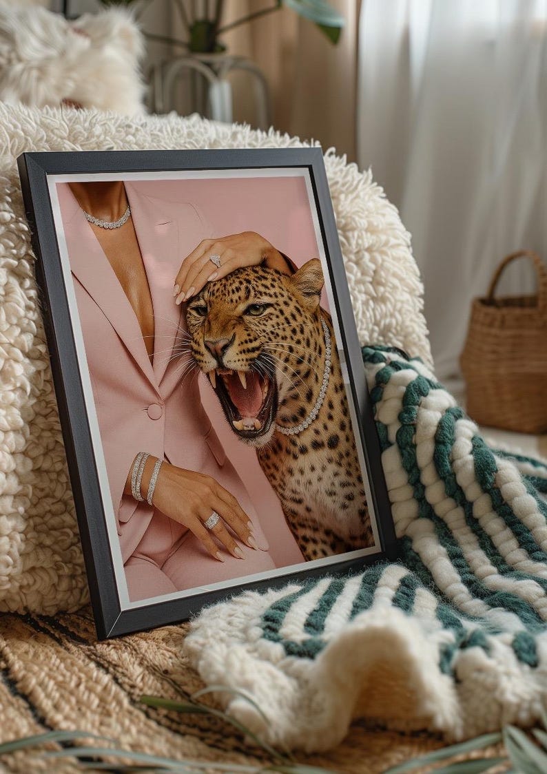 May include: Framed art print featuring a roaring leopard with a diamond necklace, set against a pink blazer. The image includes jewelry and a hand gently touching the leopard's head. The artwork is displayed on a textured surface.
