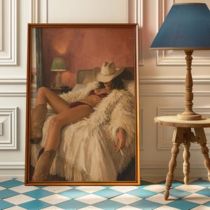 May include: A framed painting depicts a person in a cowboy hat and boots, reclining on a bed. The person is wearing a red bikini and a white fluffy coat. The painting has a warm color palette with a gold frame.