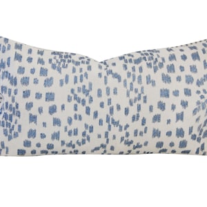 May include: A white and blue patterned lumbar pillow with a blue and white striped trim.