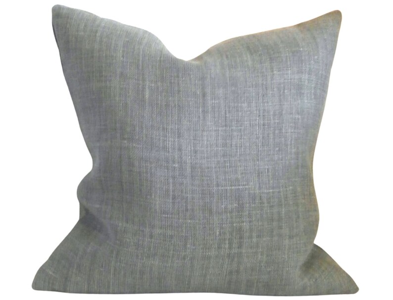 May include: A soft, grey linen pillow with a subtle textured weave. The pillow is square and has a simple, understated design.