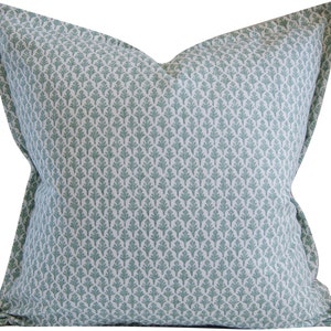May include: A light blue throw pillow with a white and light blue patterned design. The pattern features a repeating motif of small, stylized leaves.