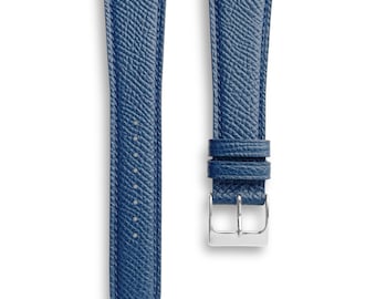 May include: Two-piece watch strap in a textured, deep blue. The strap features a silver-colored buckle and a series of evenly spaced holes for adjustment. The leather appears to have a subtle grain.