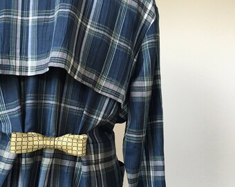 May include: A blue and white plaid shirt with a yellow bow tie. The shirt has a long sleeve and a collar.