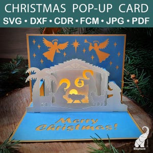 Peut inclure: Carte de Noël pop-up avec une scène de la nativité, des anges et le texte "Merry Christmas!". La carte est blanche, bleue et orange, avec un design découpé au laser. Une décoration de vacances festive.