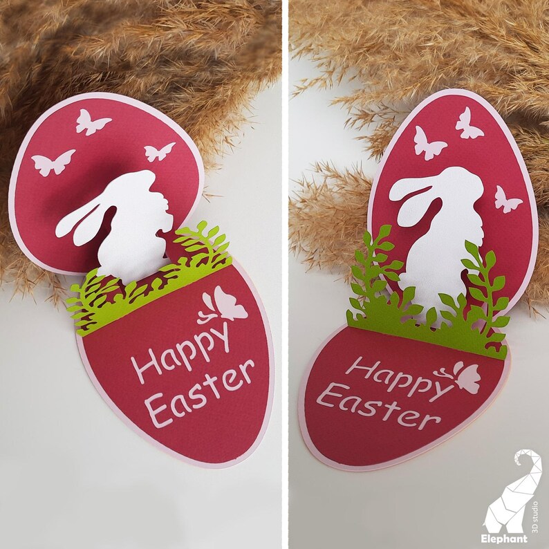 May include: A red and white paper Easter card with a pop-up bunny inside. The card has a green grass border and the words "Happy Easter" written in white.