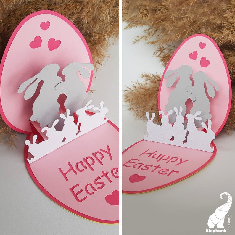 May include: A pink and white pop-up card with a 3D design of bunnies inside an egg. The card reads "Happy Easter".