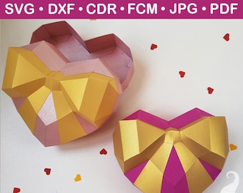 May include: Two heart-shaped boxes with gold bow accents. The boxes are pink and magenta with gold bow details. The text "HEART BOX TEMPLATE" is at the top, along with file type abbreviations. Small red heart confetti is scattered around the boxes.