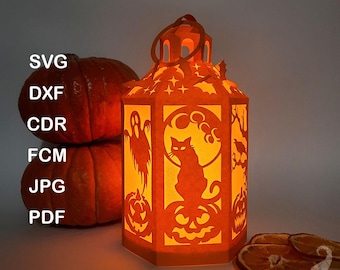 Puede incluir: Una linterna de papel naranja con recortes temáticos de Halloween: un gato, calabazas, fantasmas y murciélagos. La linterna está iluminada desde dentro, con el texto "PAPER LANTERN TEMPLATE" en la parte superior. También se ven dos calabazas y rodajas de naranja secas.