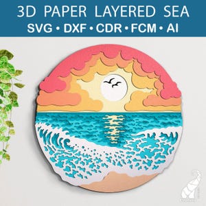 Op de afbeelding: Een gelaagd papierkunstig ontwerp van een zonsondergang boven de oceaan met een golf die op de kust breekt. Het ontwerp is in tinten roze, oranje, geel, blauw en wit.