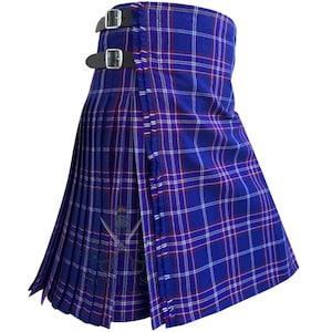 Könnte beinhalten: Ein blauer Kilt mit einem traditionellen Schottenkaro-Muster aus dünnen weißen und roten Streifen. Das Kleidungsstück verfügt über einen plissierten Bereich und ein glattes Vorderteil, das an der Taille mit zwei schwarzen Lederriemen befestigt ist.