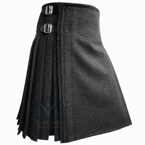May include: A dark grey kilt with pleats and leather straps with silver buckles. The kilt has a traditional design and is made of a heavy fabric. The kilt is a traditional Scottish garment.