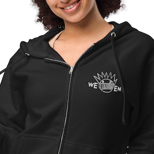 May include: Black zippered hoodie with a white embroidered graphic of a smiling face with a crown and the text "WE EN"
