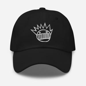 May include: Black baseball cap with a white embroidered logo of a cartoon face with a crown of spikes.