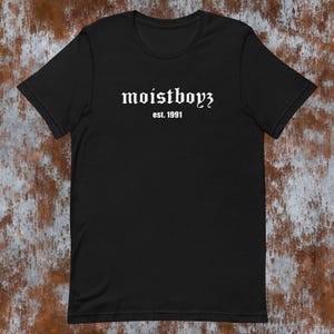 May include: Black t-shirt with white text that reads "moistboyz est. 1991".