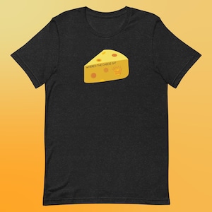 Puede incluir: Una camiseta negra con una cuña de queso de dibujos animados amarilla que dice "Where'd the cheese go?" en texto negro.
