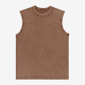 Puede incluir: Una camiseta sin mangas marr&oacute;n con cuello redondo. La camiseta tiene un aspecto descolorido y vintage y una apariencia ligeramente texturizada. El dobladillo y el cuello est&aacute;n cosidos con doble costura.