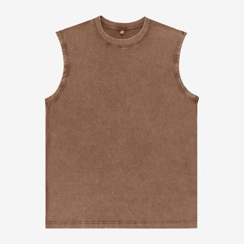 Puede incluir: Una camiseta sin mangas marr&oacute;n con cuello redondo. La camiseta tiene un aspecto descolorido y vintage y una apariencia ligeramente texturizada. El dobladillo y el cuello est&aacute;n cosidos con doble costura.