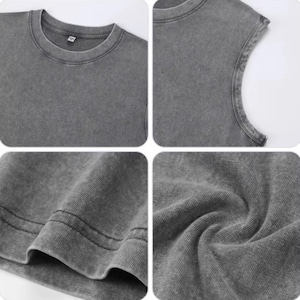 Puede incluir: Primer plano de una camiseta gris con cuello redondo. La camiseta tiene un aspecto descolorido y texturizado. La imagen muestra detalles del cuello, el hombro y el dobladillo, destacando la textura y las costuras de la tela. La camiseta parece estar hecha de un material suave y c&oacute;modo.