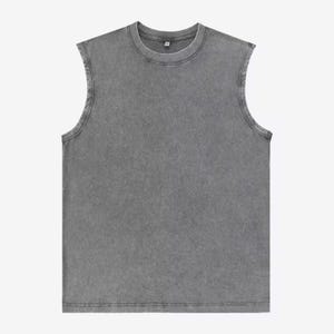 Puede incluir: Una camiseta sin mangas gris con cuello redondo. La prenda tiene un aspecto descolorido y texturizado. Las costuras son visibles y el estilo general es informal y relajado. La camiseta sin mangas est&aacute; hecha de un material suave.