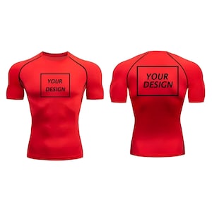 May include: A red compression shirt with short sleeves, featuring black accents along the shoulders and neckline. The front and back of the shirt each have a black square with the text "YOUR DESIGN".