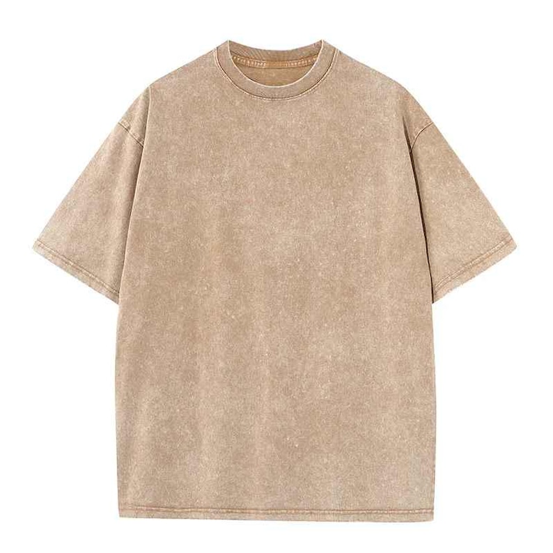 Może przedstawiać: T-shirt z kr&oacute;tkim rękawem i okrągłym dekoltem w neutralnym, beżowym kolorze. Koszulka ma lekko teksturowany wygląd i luźny kr&oacute;j. Szwy są widoczne, a og&oacute;lny styl jest swobodny i wygodny.