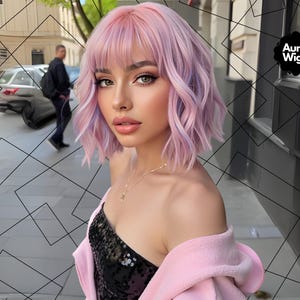 May include: A woman with a short, wavy, pink and purple wig. She is wearing a black sequined top and a pink jacket. The Aura Wigs logo is visible in the upper right corner. The background includes a street scene with a car and a person walking.