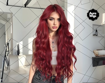 May include: A woman with long, wavy, red hair. The hair falls over her shoulders and chest. She wears a white top and denim jeans. The Aura Wigs logo is in the upper right corner.